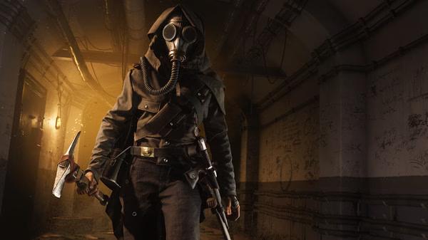 Battlefield V screenshot: A soldier in a gas mask and hood holds a weapon, standing in a dimly lit tunnel with graffiti-covered walls.