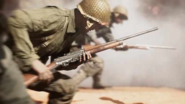 Battlefield V screenshot: Soldiers in World War II uniforms advance through smoke, holding rifles in a tense combat scene.