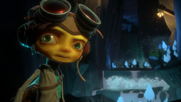 A screenshot from Psychonauts 2 showing Raz wearing goggles, standing in a glowing cave with mushrooms and a waterfall.