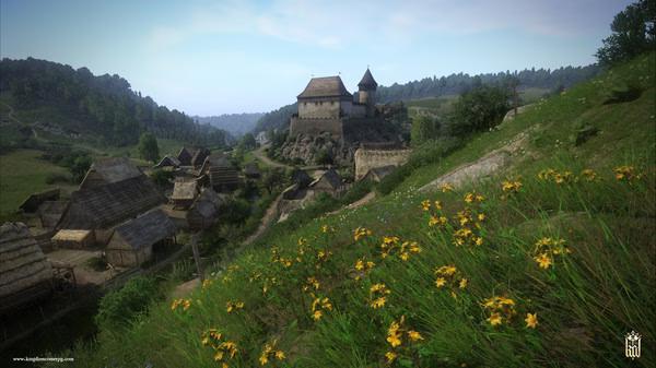 Screenshot from Kingdom Come: Deliverance showing a medieval village with a castle on a hill and wildflowers in the foreground.