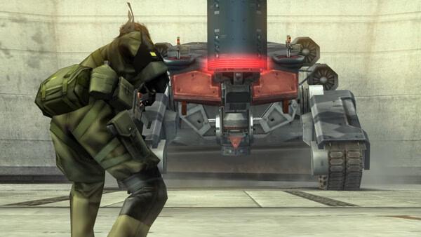A screenshot from METAL GEAR SOLID: MASTER COLLECTION Vol.2 showing a character facing off against a large mech in a concrete area.