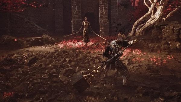 A screenshot from Mortal Shell II showing two armored warriors facing off in a dark, rocky area with red leaves scattered around.