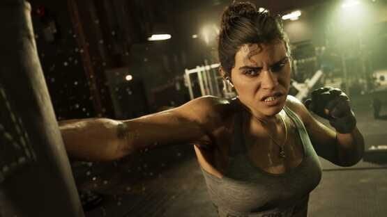 A screenshot from Grand Theft Auto VI (PlayStation 5) showing a determined woman punching a bag in a dimly lit gym.