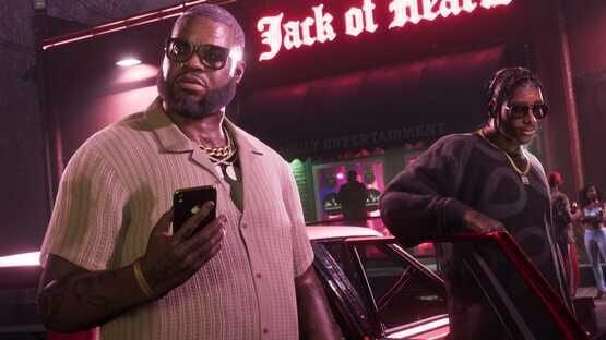 Grand Theft Auto VI (PlayStation 5) screenshot: Two characters stand near a car outside the Jack of Hearts club at night.