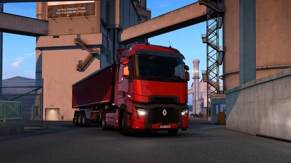 Euro Truck Simulator 2 screenshot: A red truck with a trailer parked near industrial buildings under a clear blue sky.