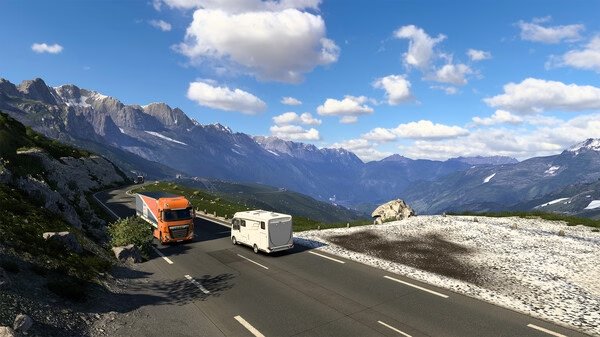 Euro Truck Simulator 2 screenshot: An orange truck driving on a mountain road with a scenic view of peaks and clouds.