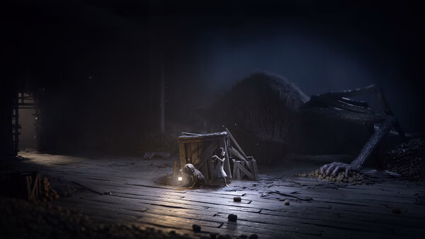 Screenshot from REANIMAL showing a small creature near a wooden crate and lantern, with a giant animal corpse in a dimly lit room.