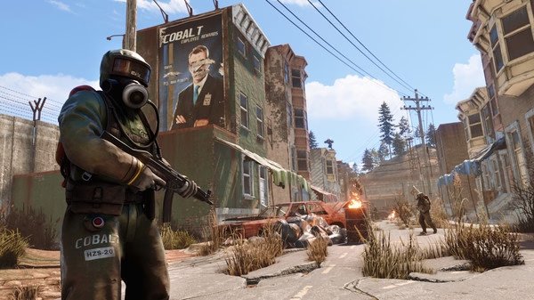 RUST screenshot: A player in a hazmat suit holding a rifle stands in a decayed urban area with abandoned cars and distant fire.