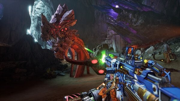 Screenshot from Borderlands 4 showing a player aiming a weapon at a large, glowing alien creature inside a dimly lit cave.