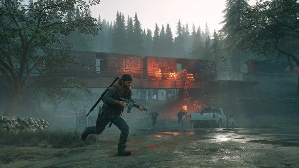 Screenshot from Days Gone showing a character running with a rifle near a burning car and zombie-like creatures in a forest setting.