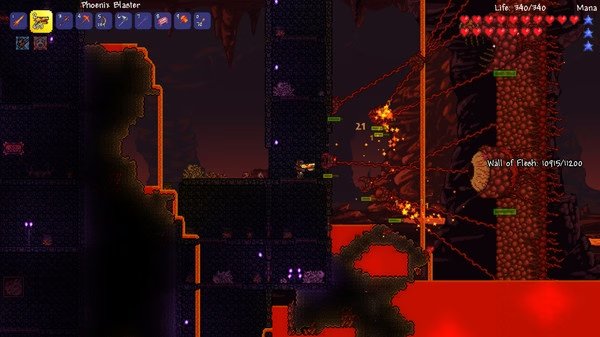 Screenshot from Terraria showing a player battling the Wall of Flesh in the Underworld, surrounded by lava and firing weapons.