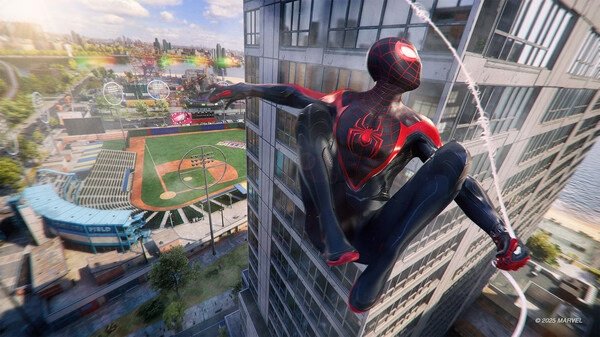 Screenshot from Marvel's Spider-Man 2 showing Miles Morales swinging past a skyscraper near a baseball stadium in daylight.