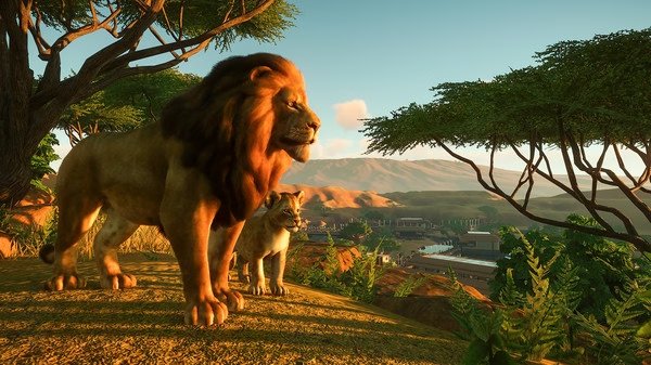 Planet Zoo screenshot showing a majestic lion and lioness standing on a hill with a sprawling savannah landscape in the background.
