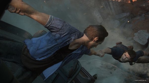 Screenshot from UNCHARTED: Legacy of Thieves Collection showing two characters gripping hands amidst a dramatic action scene.