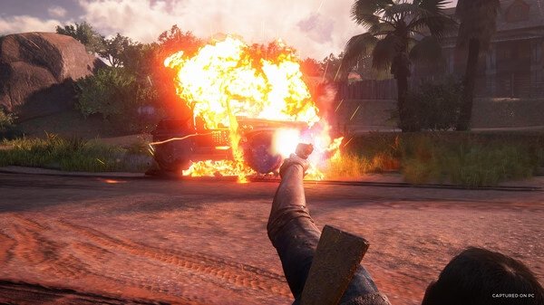 Screenshot from UNCHARTED: Legacy of Thieves Collection showing a character aiming at a car exploding in a tropical setting.