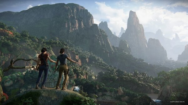 Screenshot from UNCHARTED: Legacy of Thieves Collection showing two characters overlooking a lush, mountainous landscape.