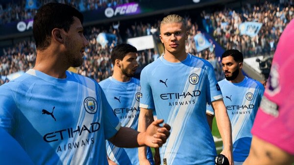EA SPORTS FC™ 26 screenshot: Soccer players in blue jerseys on the field, with a crowded stadium in the background.