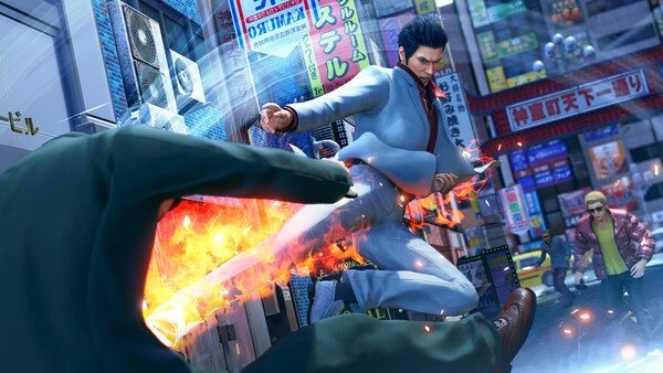 Screenshot from Yakuza Kiwami 3 & Dark Ties showing a dramatic fight scene with a character delivering a fiery kick in a bustling city.