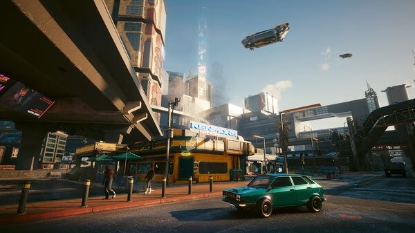 Screenshot from Cyberpunk 2077 showing a futuristic cityscape with a green car, flying vehicles, and towering buildings under a blue sky.