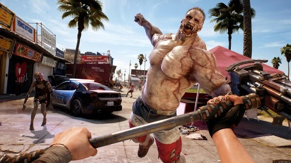 Screenshot from Dead Island 2 showing a player aiming a weapon at a large zombie in a sunny, palm-lined street scene.