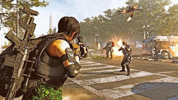Screenshot from Tom Clancy’s The Division® 2 showing an agent aiming at enemies in a street battle with a drone overhead.