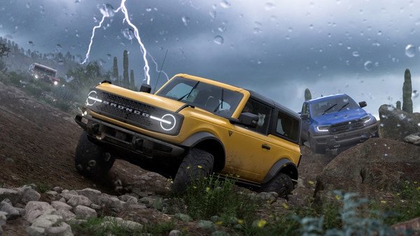 Forza Horizon 5 screenshot: A yellow off-road vehicle navigates a rocky terrain during a storm, with lightning striking in the background.