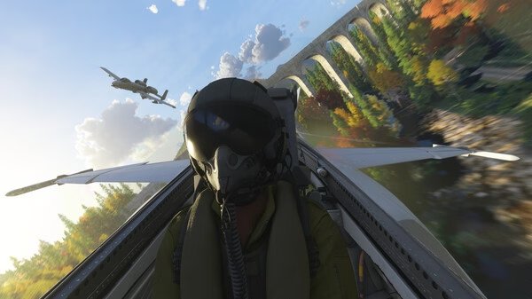 Screenshot from Microsoft Flight Simulator 2024 showing a pilot flying a jet near a scenic viaduct with vibrant autumn trees.