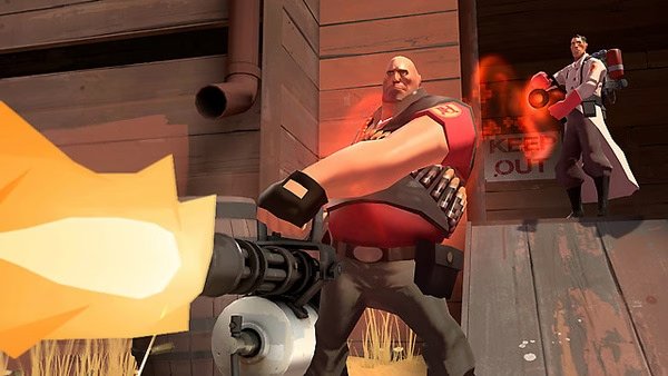 Team Fortress 2 screenshot showing a Heavy firing a minigun, with a Medic behind him using a healing beam near a wooden structure.