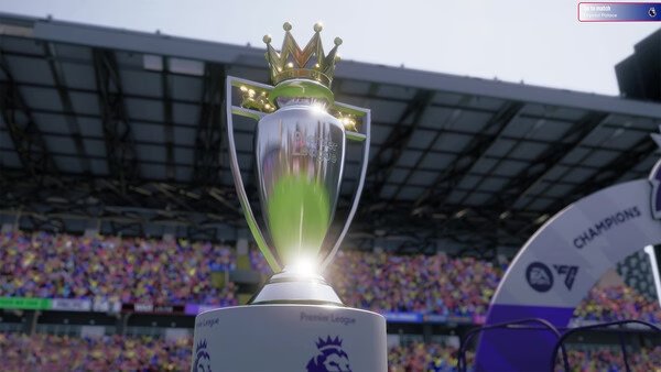 Screenshot from Football Manager 26 showing a detailed close-up of the Premier League trophy in a packed stadium.