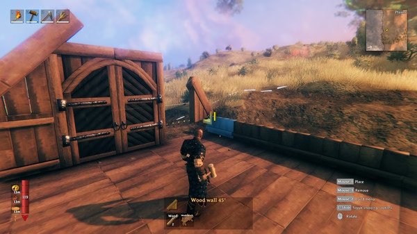 A Valheim screenshot showing a player building a wooden structure with a hammer, set in a grassy outdoor environment.