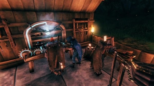 Valheim screenshot: A player in a blue cloak works at a forge inside a wooden workshop, surrounded by tools and glowing lights.