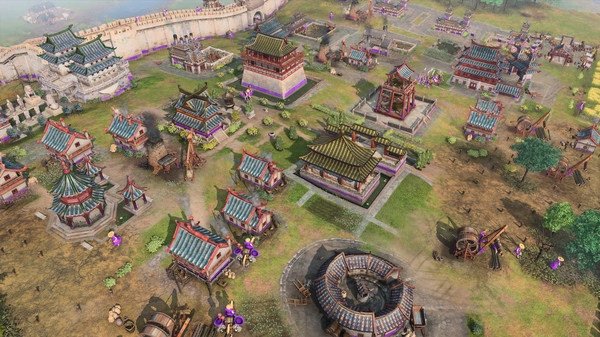 Screenshot of Age of Empires IV showing a bustling medieval Asian village with colorful buildings and a protective wall in the background.