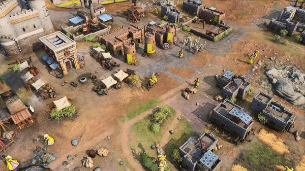 Age of Empires IV screenshot showing a medieval town with buildings, tents, and soldiers scattered across a grassy landscape.