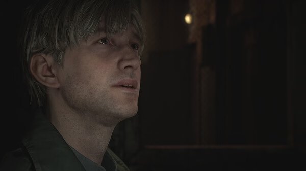 Silent Hill 2 screenshot: A close-up of a character with blurred features, set against a dimly lit, eerie background.