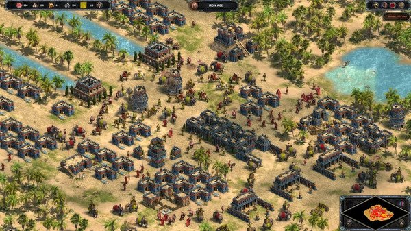 Screenshot from Age of Empires Definitive Edition showing a bustling ancient city with numerous buildings and units in a desert landscape.