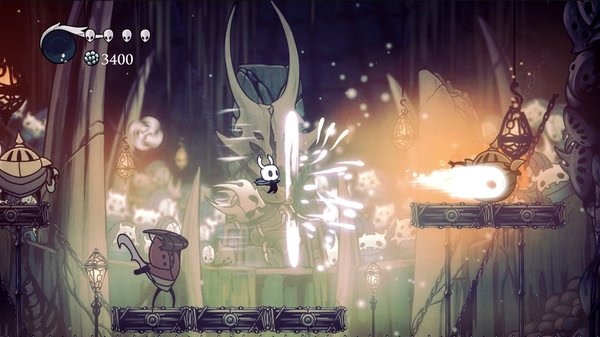 Hollow Knight screenshot: The Knight battles a bug-like enemy in an underground cavern with glowing elements and a health bar.