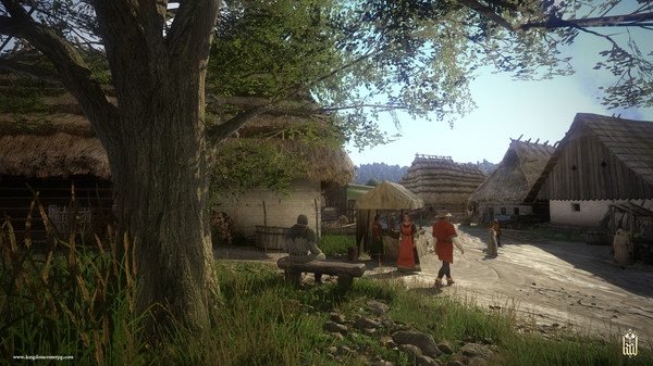A 'Kingdom Come: Deliverance' screenshot showing a village scene with thatched houses, villagers, and a man resting under a tree.