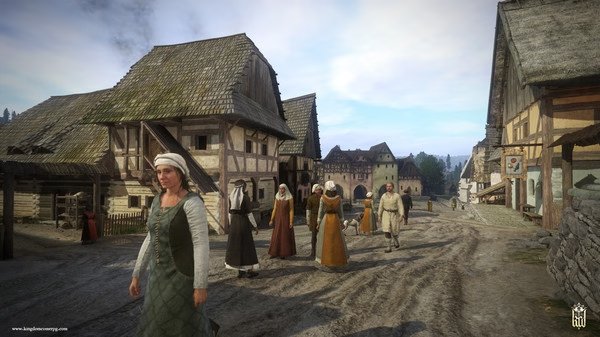 A bustling medieval village scene in Kingdom Come: Deliverance, showing villagers walking on a dirt road. Screenshot from the game.
